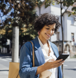 person looking at a cellphone outside happily