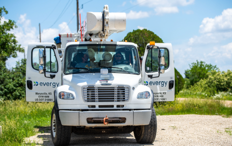 Evergy worker truck with doors open on a gravel path