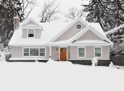 white house with an orange door and a snowy yard
